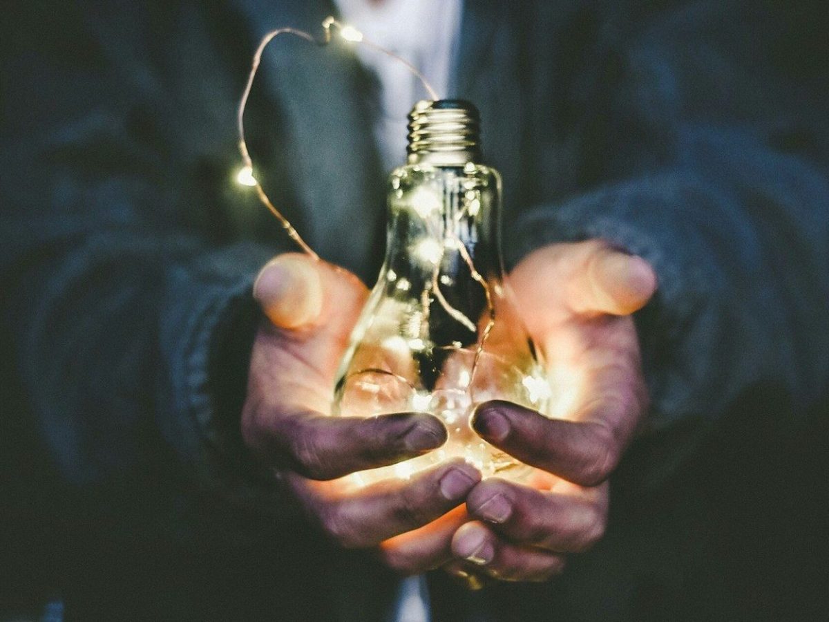 man holding incandescent bulb