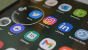 A close up of a cell phone with various social icons